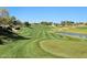 Golf course overlooking green and lake with modern luxury homes in the background at 15802 N 71St St # 501, Scottsdale, AZ 85254