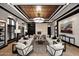 Bright living room with coffered ceiling, stone fireplace, neutral furnishings, and large windows at 15802 N 71St St # 501, Scottsdale, AZ 85254
