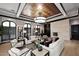 Bright living room with coffered ceiling, stone fireplace, neutral furnishings, and large windows at 15802 N 71St St # 501, Scottsdale, AZ 85254