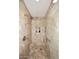 Walk-in shower featuring travertine tile, a built-in niche, and a shower seat at 15802 N 71St St # 501, Scottsdale, AZ 85254