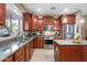 Traditional kitchen features wood cabinetry, granite countertops, stainless steel appliances, and a tile floor at 1708 W Seagull Ct, Chandler, AZ 85286