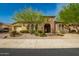 Charming home featuring a stone archway entrance, desert landscaping, and a well-manicured front yard at 18068 W Narramore Rd, Goodyear, AZ 85338