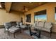 Comfortable covered outdoor patio features ceiling fan, with furniture for relaxing and entertaining at 18068 W Narramore Rd, Goodyear, AZ 85338