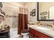 Bathroom featuring stylish granite countertops, tile accents, and a shower-tub combo at 18118 W Redwood Ln, Goodyear, AZ 85338
