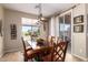 Inviting dining room with wood table, padded chairs, decorative light fixture, and sliding glass doors at 18118 W Redwood Ln, Goodyear, AZ 85338