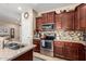 Well-equipped kitchen with granite countertops, stainless steel appliances, and dark wood cabinets, open to the living area at 18118 W Redwood Ln, Goodyear, AZ 85338