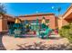 Outdoor patio area with seating, umbrellas, and lush greenery in a well-maintained community setting at 18665 N Patina Ct, Surprise, AZ 85387