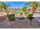 Lush backyard featuring desert landscaping, mature palm trees, a putting green, and a tranquil rock garden at 19 N Agua Fria Ln, Casa Grande, AZ 85194