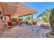 Backyard patio with pergola, offering a shaded seating area with comfortable chairs and a beautiful view at 19 N Agua Fria Ln, Casa Grande, AZ 85194