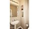 Cozy bathroom with a pedestal sink, stylish mirror, and built-in decorative wall niches at 19475 N Grayhawk Dr # 1018, Scottsdale, AZ 85255