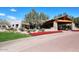 Elegant building entrance featuring a covered portico, stone columns, and landscaped grounds at 19475 N Grayhawk Dr # 1018, Scottsdale, AZ 85255