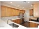 Well-lit kitchen featuring light wood cabinets, stainless steel appliances, and stylish mosaic backsplash at 19475 N Grayhawk Dr # 1018, Scottsdale, AZ 85255
