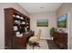 Inviting office space featuring a built-in desk, ample shelving, and a comfortable chair on a decorative rug at 19475 N Grayhawk Dr # 1018, Scottsdale, AZ 85255