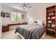 Neutral bedroom featuring a ceiling fan, window with shutter-style blinds, desk, and an open bookcase at 22181 N 78Th St, Scottsdale, AZ 85255