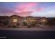 Exterior twilight view of a single-story home with stone accents, desert landscaping, and a desert sunset at 22181 N 78Th St, Scottsdale, AZ 85255