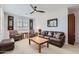 Bright living room with a wooden coffee table, comfortable seating, and modern ceiling fan at 22181 N 78Th St, Scottsdale, AZ 85255
