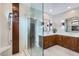 Bright main bathroom with a glass-enclosed shower, double vanity with wood cabinets, and a walk-in closet at 22181 N 78Th St, Scottsdale, AZ 85255