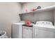 Functional laundry room with a washer, dryer, and upper shelving for supplies at 22452 E Calle De Flores --, Queen Creek, AZ 85142