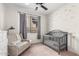 Neutral Bedroom with grey chair, crib, and window at 23103 E Mewes Rd, Queen Creek, AZ 85142