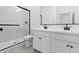 Modern bathroom with double sinks, sleek white cabinets, and a glass-enclosed shower at 23435 W Albeniz Pl, Buckeye, AZ 85326