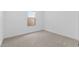 A minimalist bedroom with neutral carpet, white walls, and a window at 23435 W Albeniz Pl, Buckeye, AZ 85326
