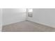 A minimalist bedroom with neutral carpet, white walls, and a window at 23435 W Albeniz Pl, Buckeye, AZ 85326