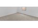 A minimalist bedroom with neutral carpet, white walls, and a window at 23435 W Albeniz Pl, Buckeye, AZ 85326