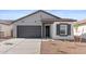 Beautifully designed single-Gathering home with gray siding, black accents, and a well-maintained front yard at 23435 W Albeniz Pl, Buckeye, AZ 85326