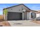 Inviting single-Gathering home with a dark garage door, gray vertical siding and contrasting black trim on a sunny day at 23435 W Albeniz Pl, Buckeye, AZ 85326