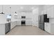 Bright and airy kitchen with white cabinets, stainless steel appliances, a large island, and wood-look tile flooring at 23435 W Albeniz Pl, Buckeye, AZ 85326