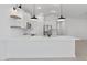 Well-lit kitchen featuring white cabinets, stainless steel appliances, a large island, and stylish pendant lighting fixtures at 23435 W Albeniz Pl, Buckeye, AZ 85326