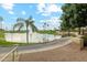 Scenic view of a community pond with a fountain, lush landscaping, and palm trees at 23702 S Desert Sands Dr, Sun Lakes, AZ 85248