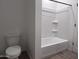 Bright bathroom showcasing a new toilet and tub/shower combo with tiled walls and a white shower curtain rod at 24080 W Bowker St, Buckeye, AZ 85326