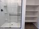 Modern bathroom features a glass shower, built-in shelving, and sleek fixtures at 24080 W Bowker St, Buckeye, AZ 85326
