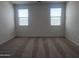 Bright bedroom offers neutral carpeting, dual windows, and ample natural light at 24080 W Bowker St, Buckeye, AZ 85326