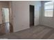 This bedroom has neutral colored carpet, white walls, and a sliding door closet and lots of natural light at 24080 W Bowker St, Buckeye, AZ 85326