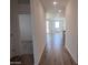 Inviting hallway with wood-look tile floors that leads into the kitchen and living area with lots of natural light at 24080 W Bowker St, Buckeye, AZ 85326