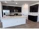 Modern kitchen features stainless steel appliances, a center island, and dark wood cabinets at 24080 W Bowker St, Buckeye, AZ 85326