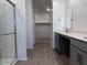 Bathroom features a glass shower, double vanity with gray cabinets and hard surface countertops at 24088 W Bowker St, Buckeye, AZ 85326