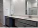 Bathroom with double sinks, gray vanity, and wood-look tile flooring at 24088 W Bowker St, Buckeye, AZ 85326