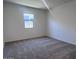 Bedroom features a large window that provides natural light and neutral colored carpeted floors at 24088 W Bowker St, Buckeye, AZ 85326