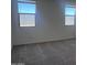 Bedroom featuring 2 large windows that provide natural light and neutral colored carpeted floors at 24088 W Bowker St, Buckeye, AZ 85326