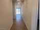 Bright hallway featuring tile flooring leading to a sliding glass door at the end at 24088 W Bowker St, Buckeye, AZ 85326