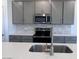Bright kitchen featuring stainless steel appliances, gray cabinetry, and a center island with sink at 24088 W Bowker St, Buckeye, AZ 85326