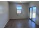 Living room with wood tile floors, white walls, and sliding glass door at 24088 W Bowker St, Buckeye, AZ 85326