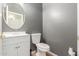 Powder room with a modern vanity, decorative mirror, toilet, and neutral paint at 24824 W Pueblo Ave, Buckeye, AZ 85326