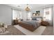 Modern bedroom with neutral colors, a wooden bed frame, minimalist decor, and plenty of natural light from dual windows at 24824 W Pueblo Ave, Buckeye, AZ 85326
