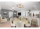 Bright dining area featuring an elegant light fixture, a wood table, and an open view to the kitchen and living room at 24824 W Pueblo Ave, Buckeye, AZ 85326