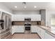 Modern kitchen with stainless steel appliances, granite countertops, and white cabinets, offering ample storage at 24824 W Pueblo Ave, Buckeye, AZ 85326