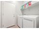 Laundry room with washer, dryer, storage shelves, and access to the home's exterior at 24824 W Pueblo Ave, Buckeye, AZ 85326